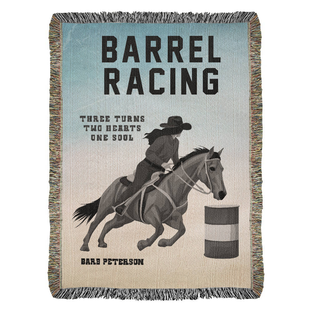 A personalized woven blanket with a barrel racing theme, featuring an illustration of a person on a horse, making a turn around the barrels. The text 'BARREL RACING' is prominently displayed at the top with the saying Three Turns, Two Hearts, One Soul. The ability to customize the blanket with the persons name is on the bottom.