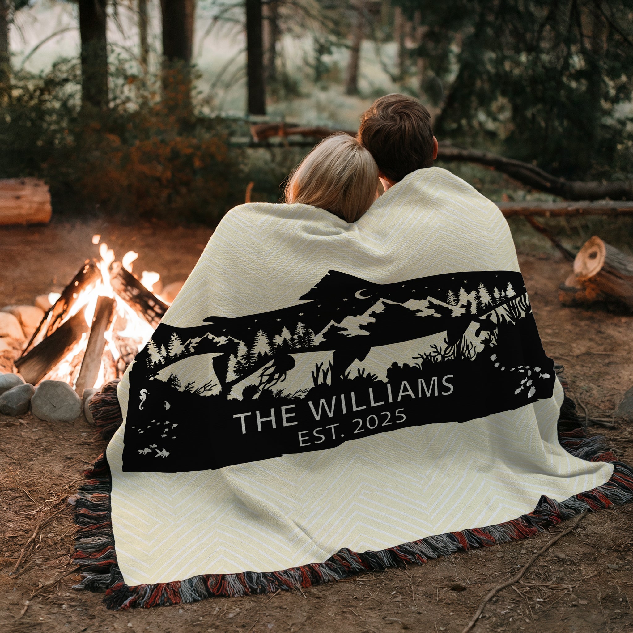 Personalized Woven Blanket with nature fish design and monogramed name with Est. year. Blanket on patio bench outdoors.Two people sitting by a campfire, wrapped in a blanket with a personalized design and text.Available at FunLifeNow.com