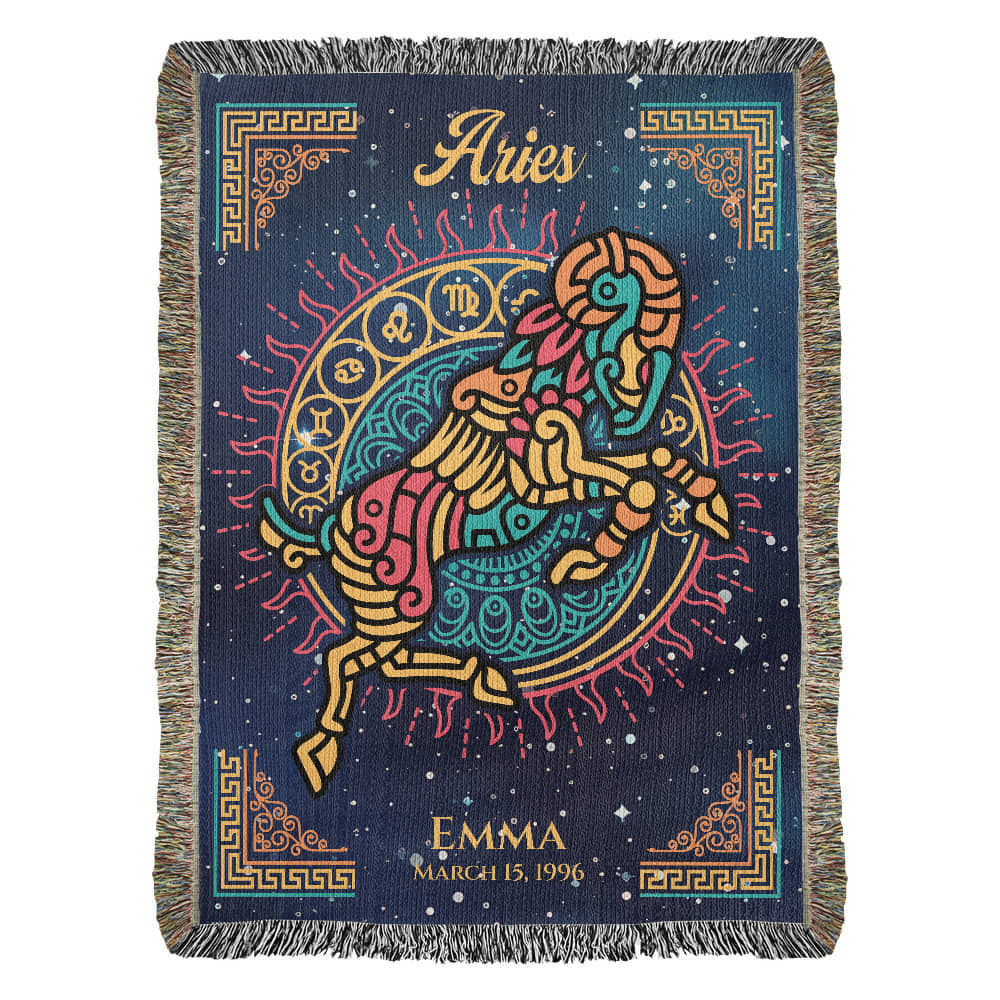 A personalized woven blanket with Aries zodiac sign and a name, Emma, in the corner. The blanket has a dark background with a colorful fringe and astrological symbols.