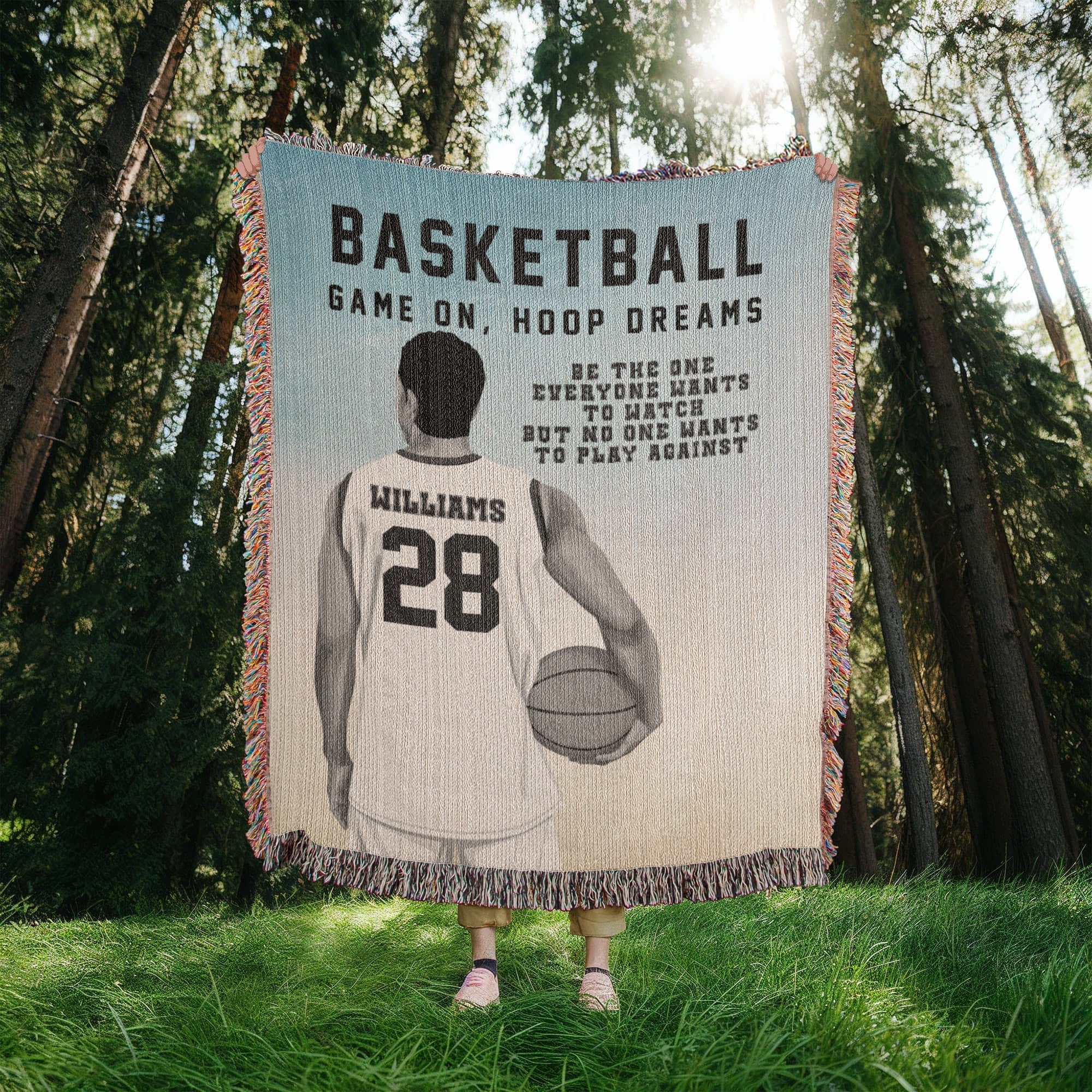 Person holding a personalized blanket with a basketball design and text in a forest setting. Player name and jersey number are customizable