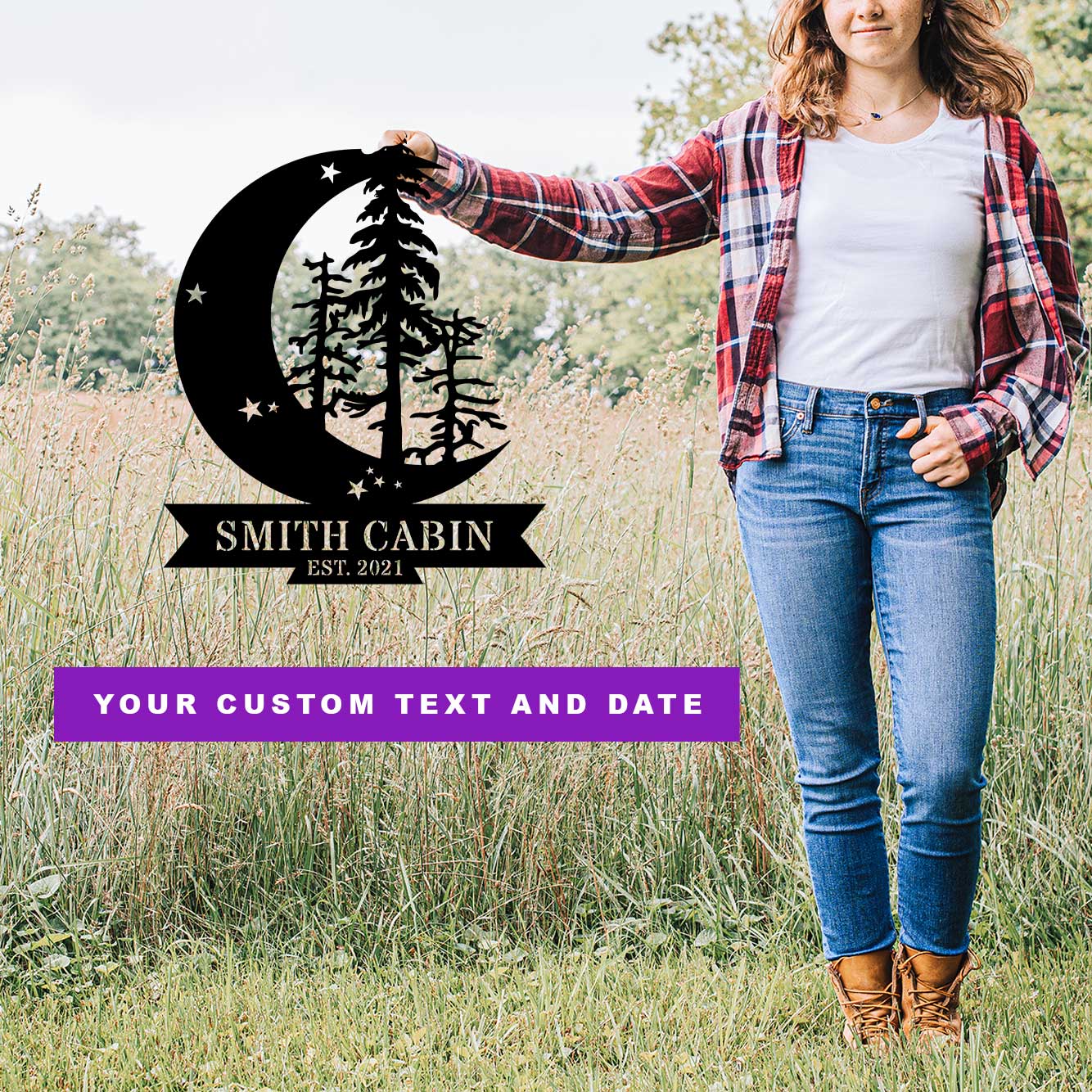 Person holding a metal wall art sign with a crescent moon and tree design and text in a grassy field. Personalized text and date on the wall art.