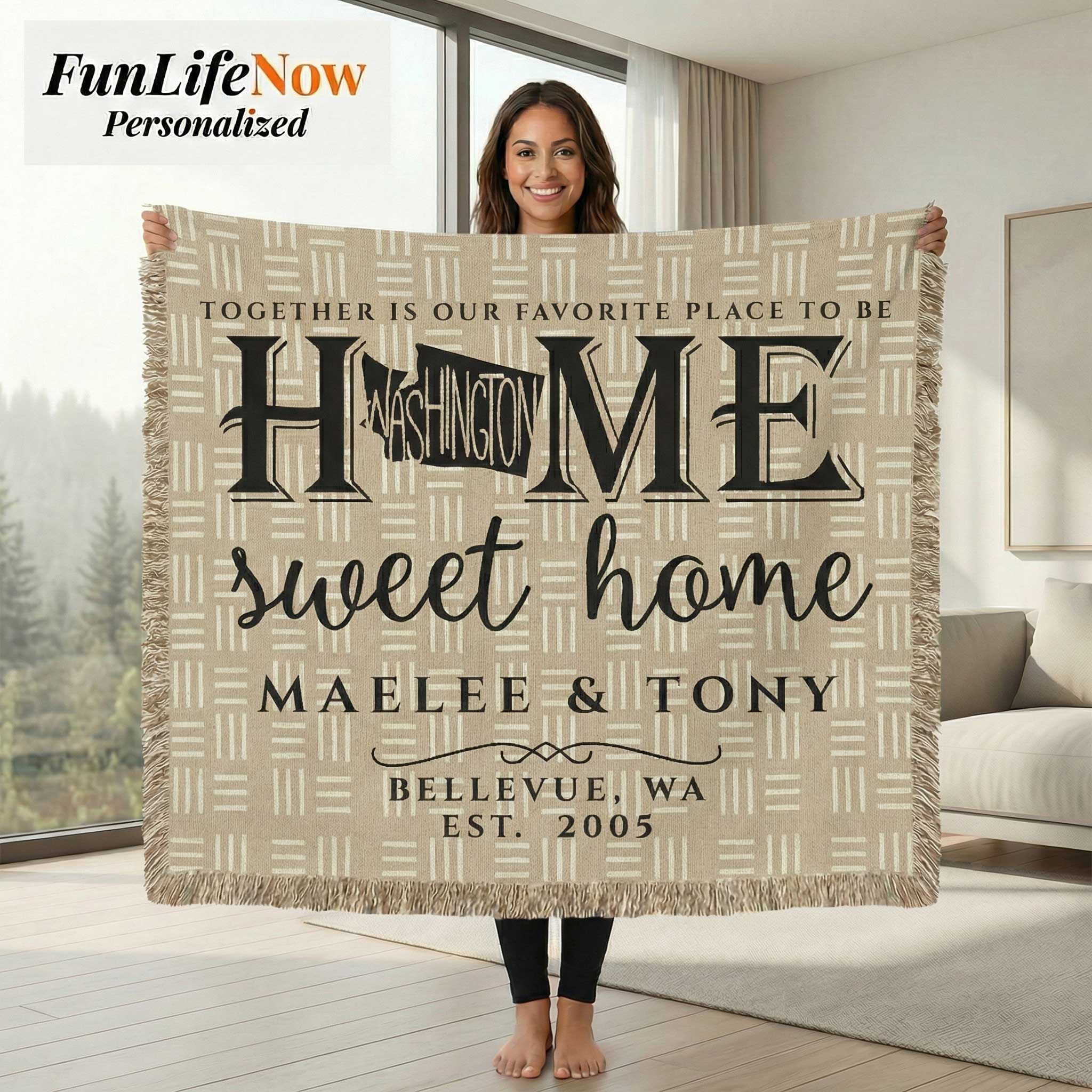 Person holding a personalized blanket with 'Home sweet home' text in a living room.
