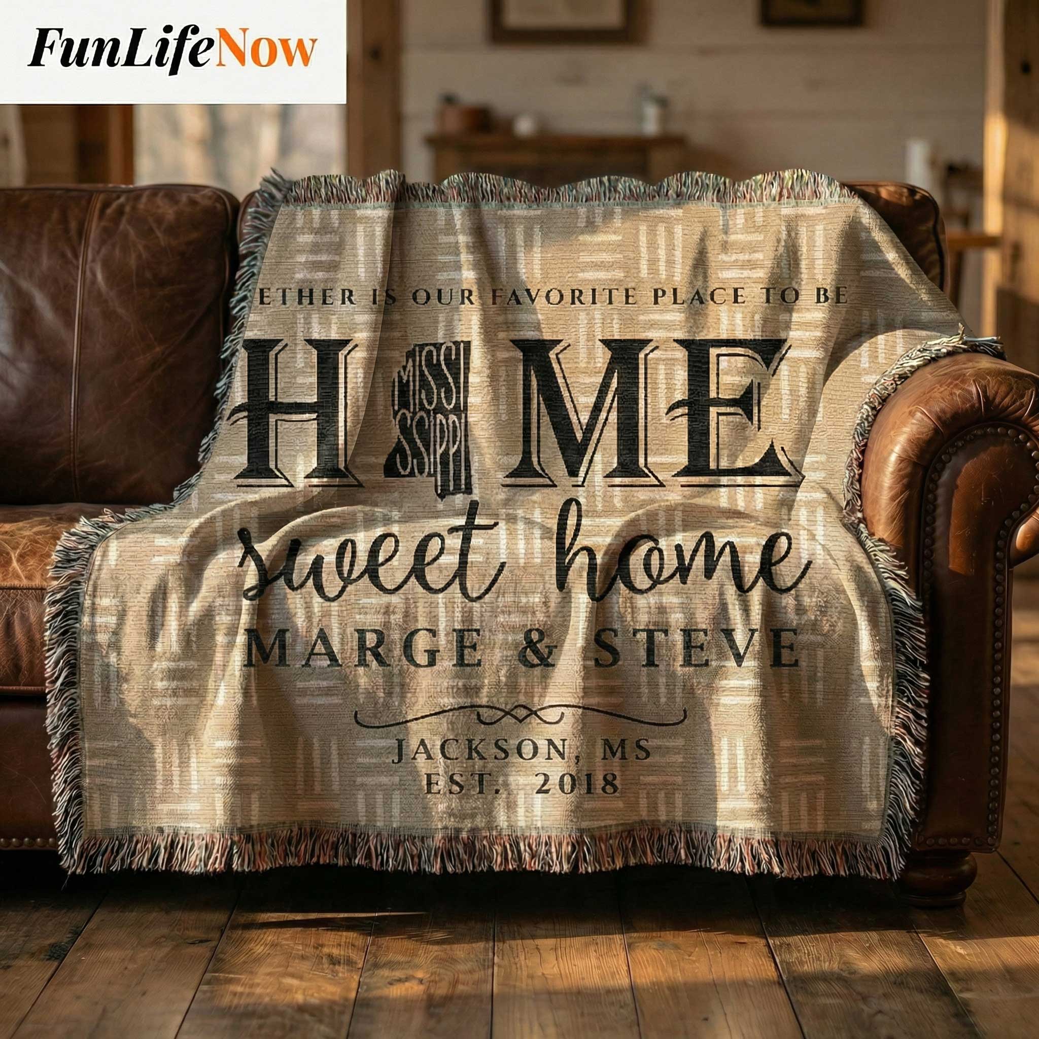 Personalized blanket with 'Home sweet home' text draped over a brown leather couch. Personalized Mississippi blanket available at funlifenow.com