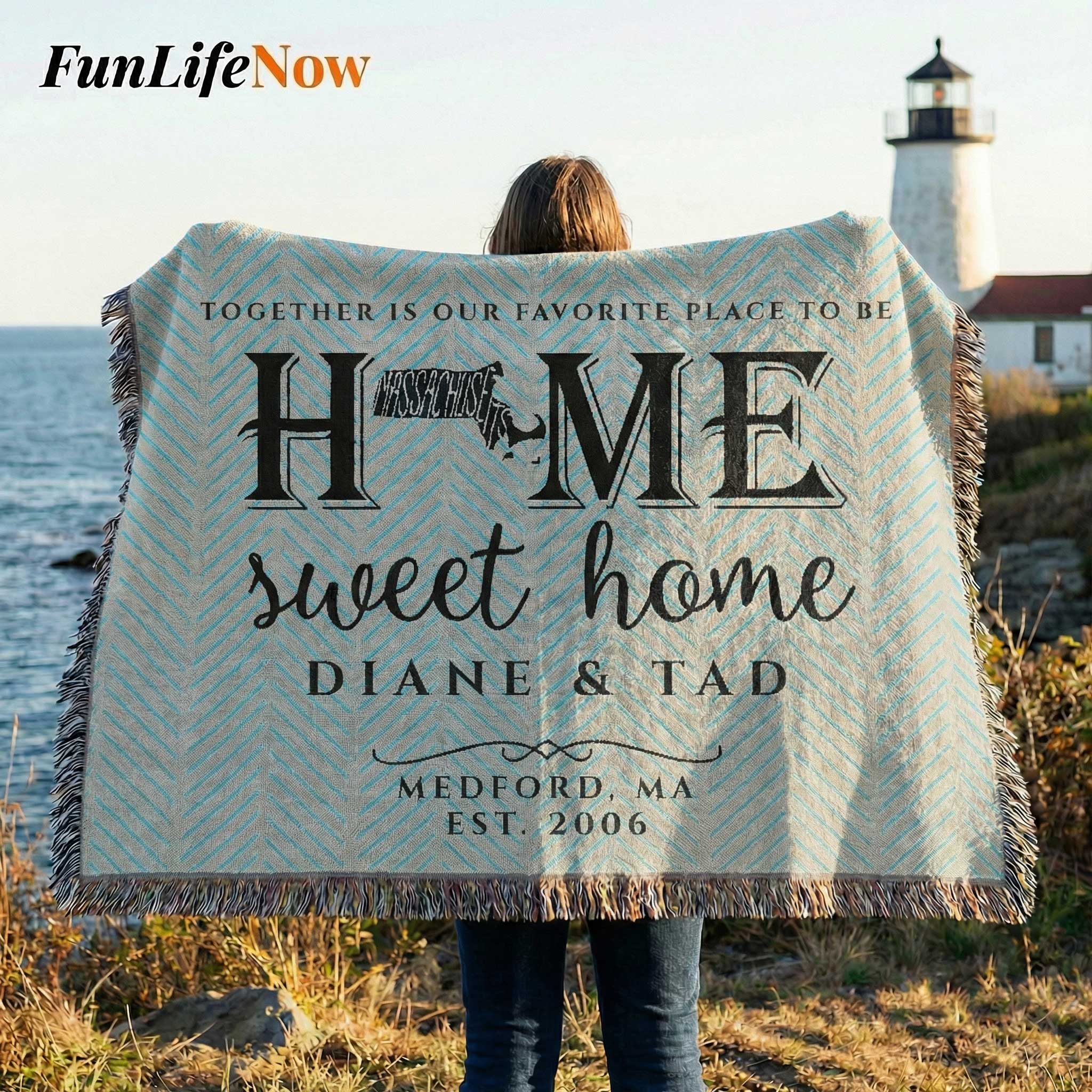 Person holding a personalized blanket with 'Home sweet home' text by a lighthouse. Blanket available at funlifenow.com