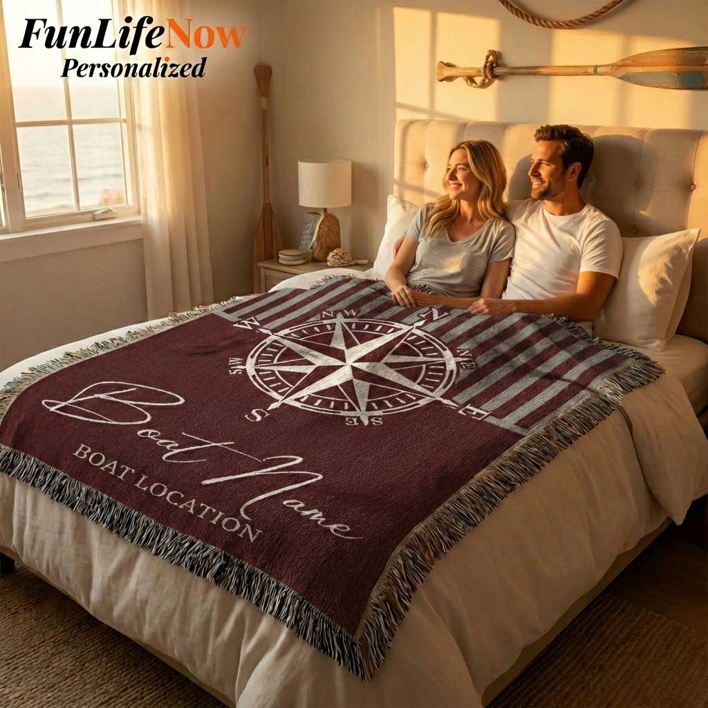 Couple sitting on a bed with a personalized nautical boating blanket featuring a compass design. Custom blanket available at funlifenow.com