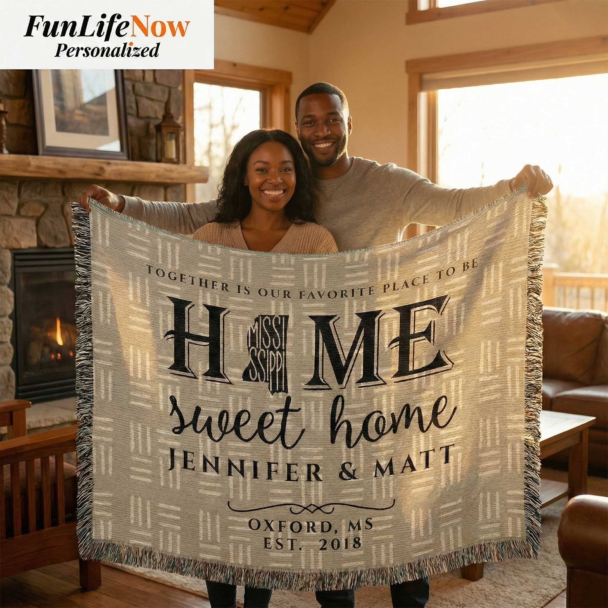 Couple holding a personalized 'Home Sweet Home' blanket in a cozy living room. Personalized Mississippi blanket available at funlifenow.com