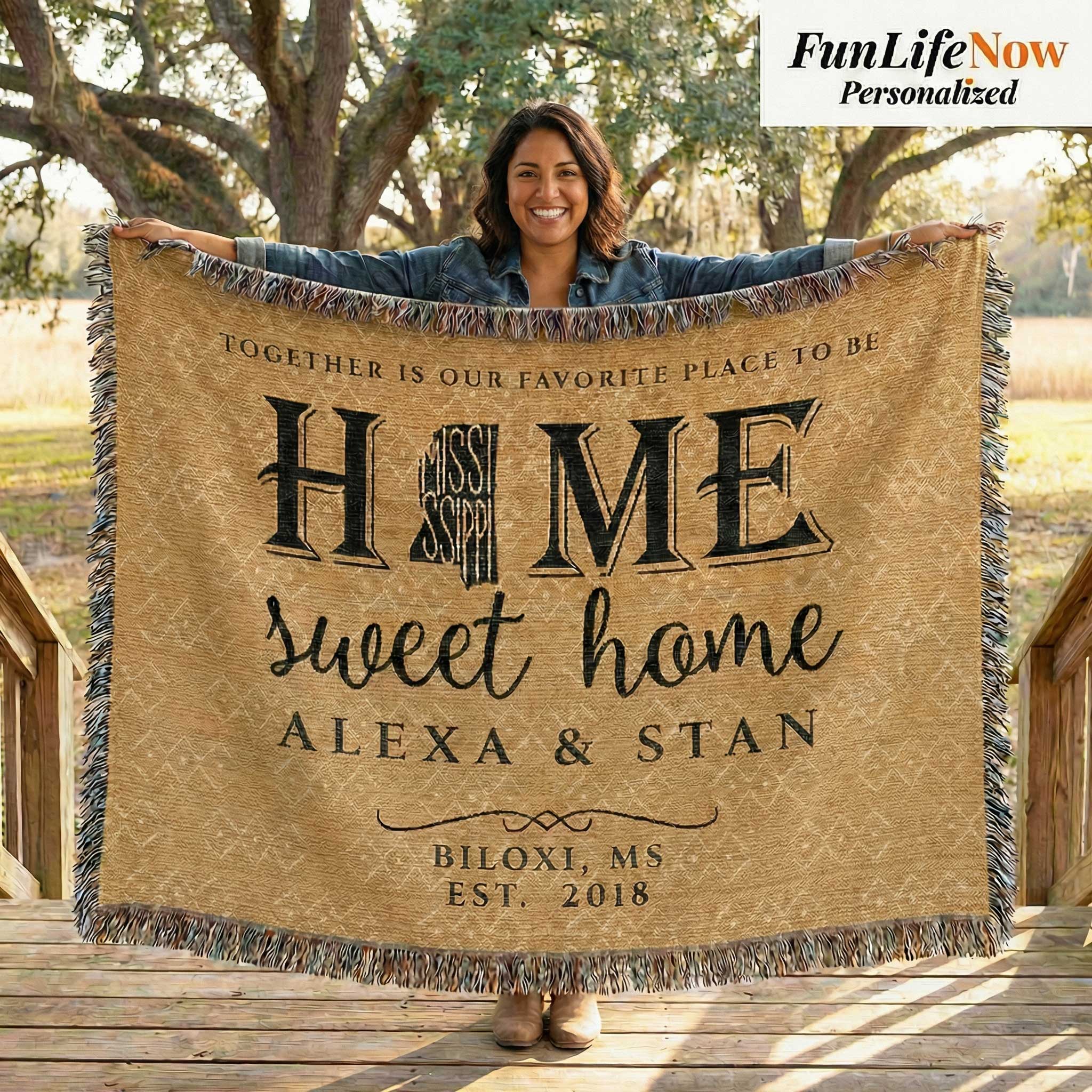 Person holding a personalized blanket with 'Home sweet home' and names printed on it, outdoors. Personalized Mississippi blanket available at funlifenow.com