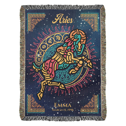A personalized woven blanket with Aries zodiac sign and a name, Emma, in the corner. The blanket has a dark background with a colorful fringe and astrological symbols.